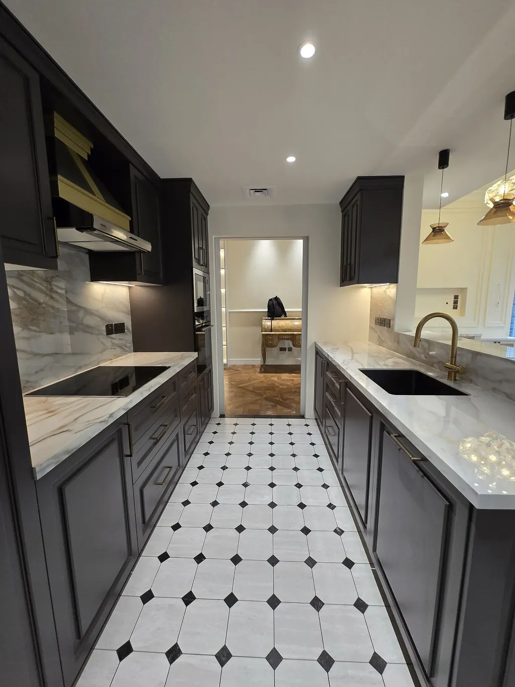 Kitchen galley with charcoal panelled units and stone worktops
