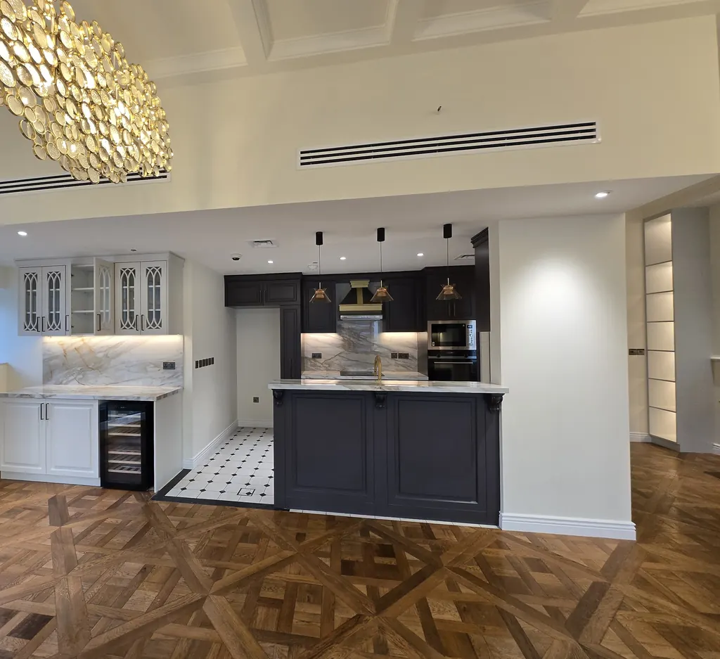 Open-plan living and kitchen under coffered ceilings with a chandelier