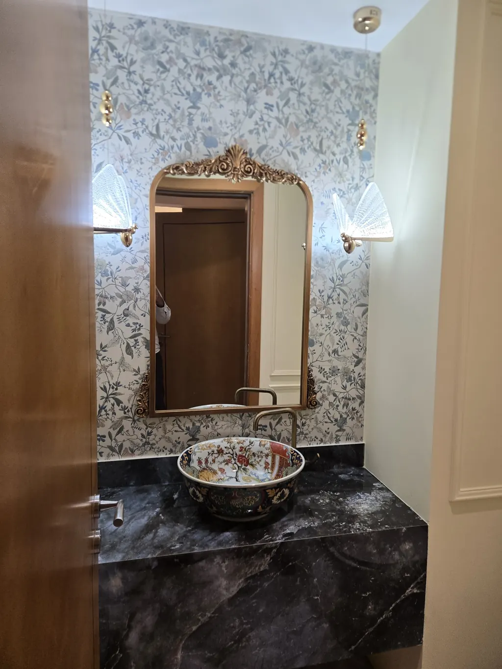 Powder room with a gilded mirror, mosaic wall and stone vanity