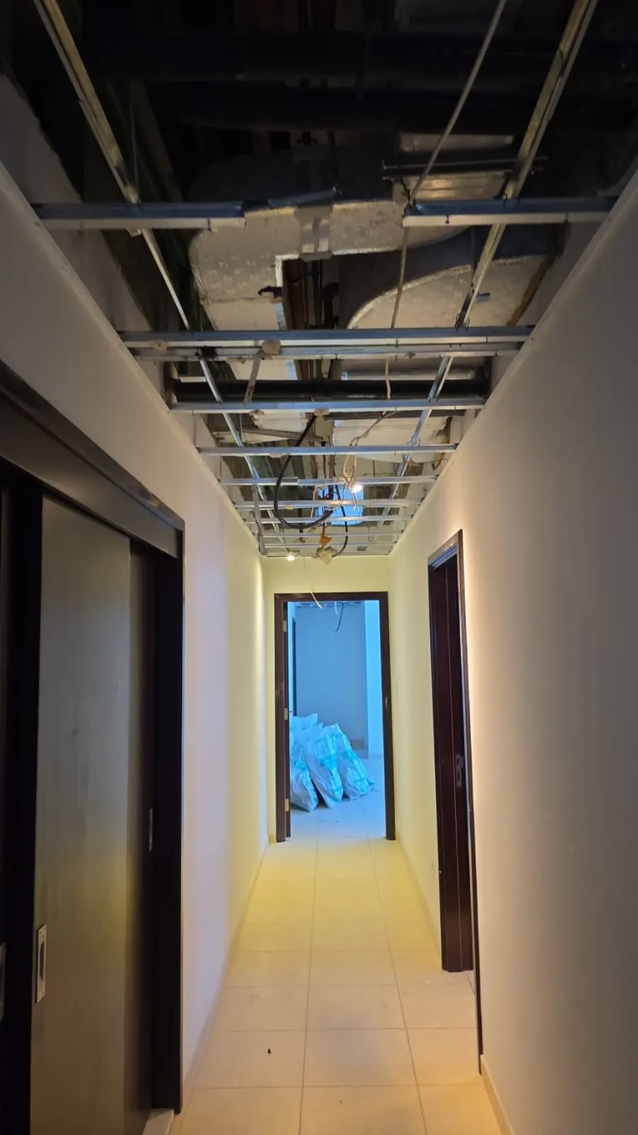 The long corridor at strip-out, ceiling opened to the services