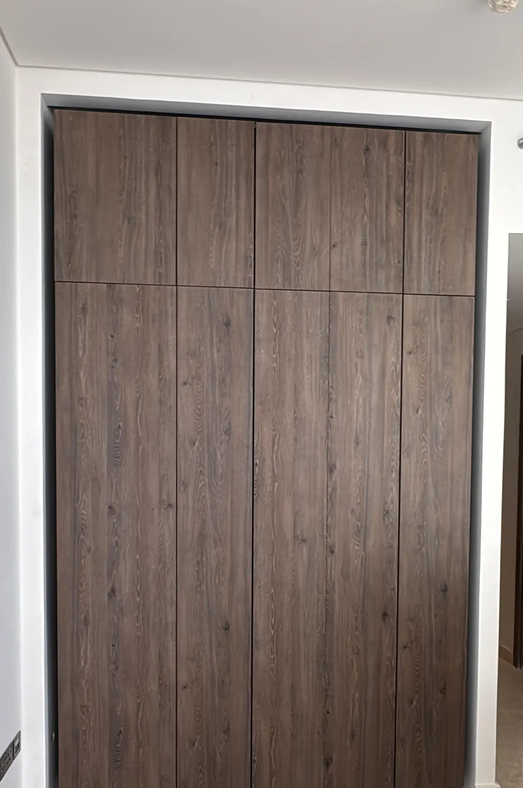 Bedroom wardrobe after: full-height oak-look fronts to the ceiling