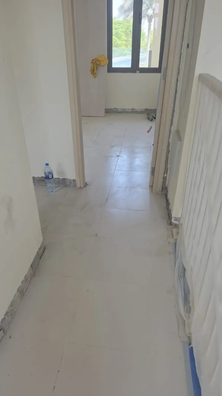The same hall before, with the old floor lifted and the walls being prepared